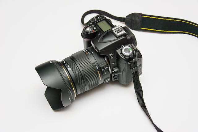 a professional photography camera with a long lens on a white table